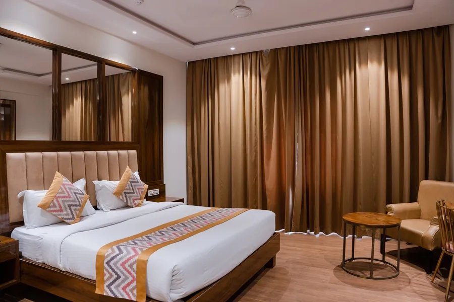 Furnished bedroom with mattress, bed linen and full-length curtains